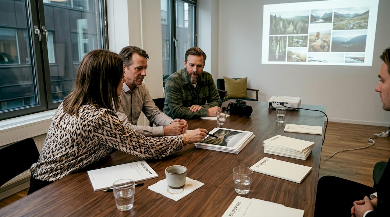 Ett team samlas runt konferensbordet för att diskutera företagets bildstrategi.