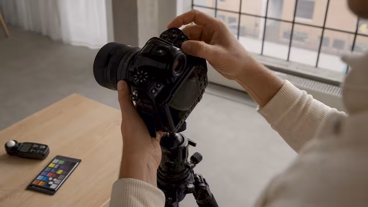 En fotograf finjusterar inställningarna på sin kamera för att få till den perfekta bilden.